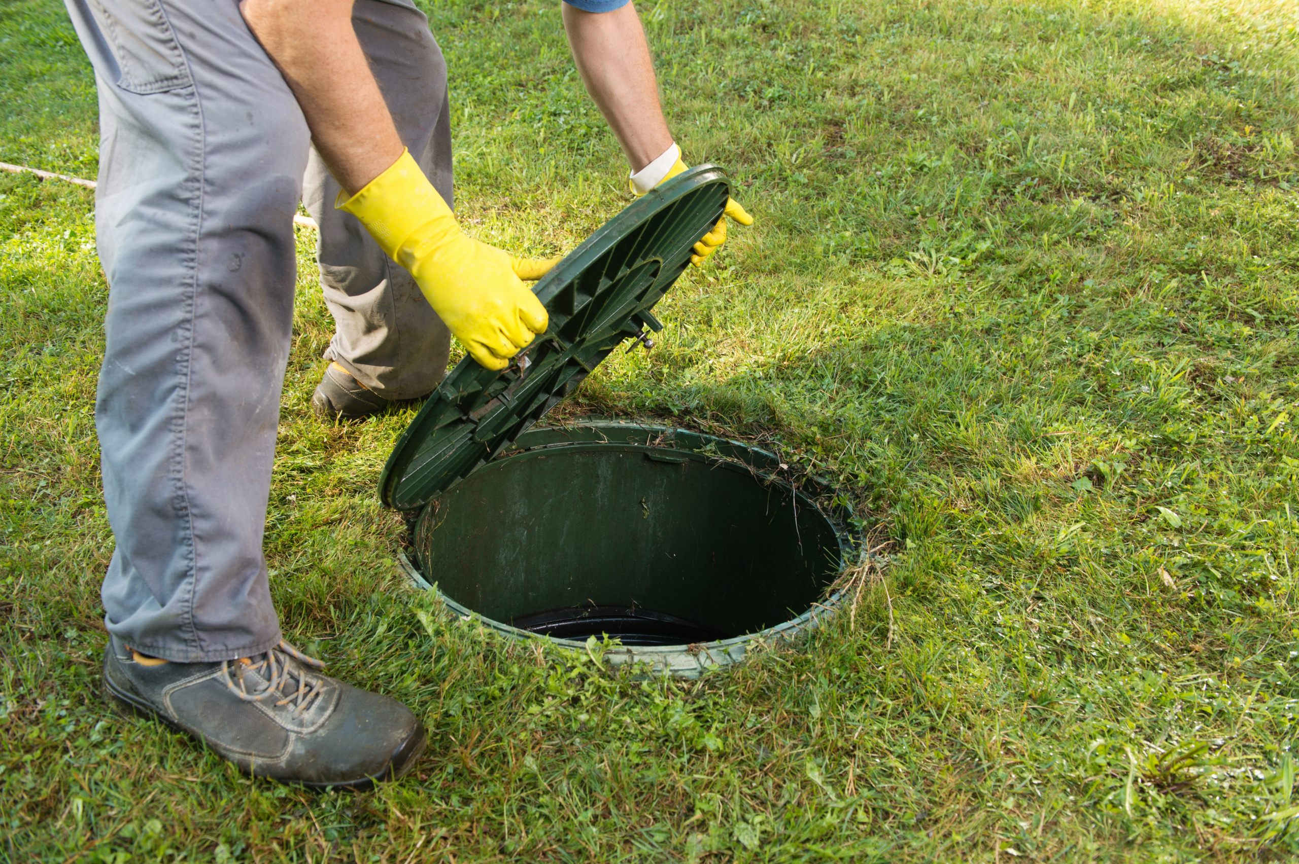 Opening septic tank lid. Cleaning and unblocking septic system and draining pipes.........